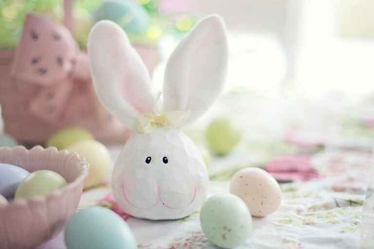 white rabbit figurine on white and pink floral textile